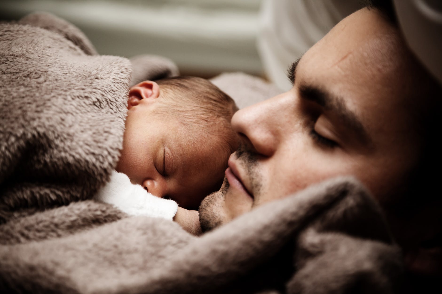man and baby sleeping together